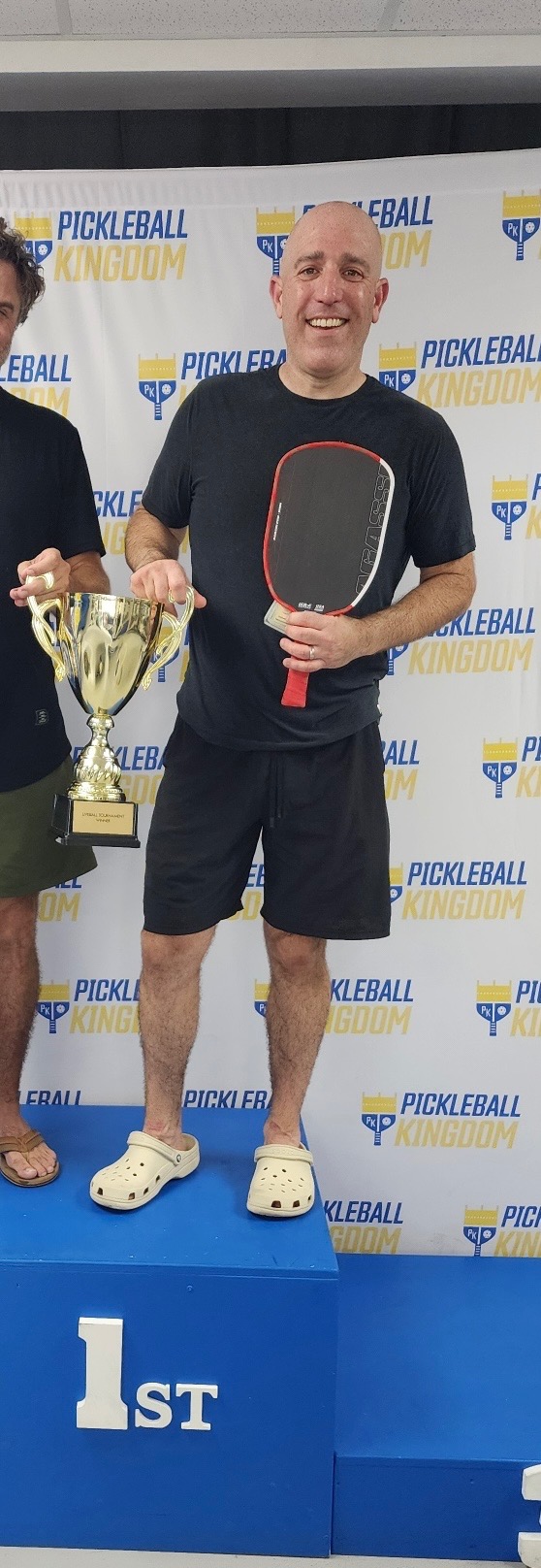 Evan Gremont holding a 1st place trophy at a pickleball tournament